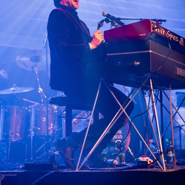 Musician playing a keyboard in blue light